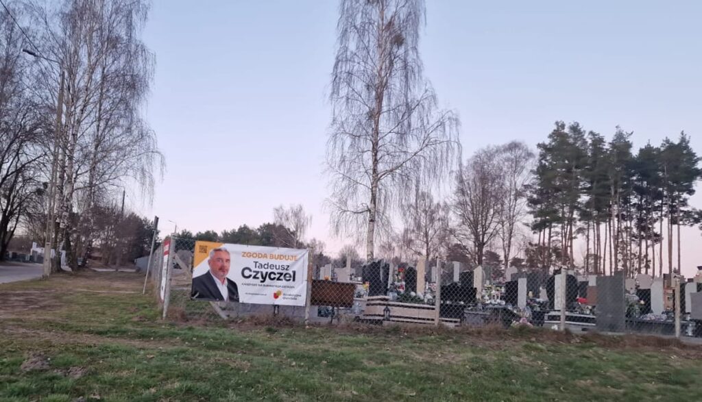 Wywieszanie plakatów wyborczych na ogrodzeniu cmentarza: społeczność Ostródy dzieli się swoimi opiniami 13 Plakat wyborczy na ogrodzeniu cmentarza