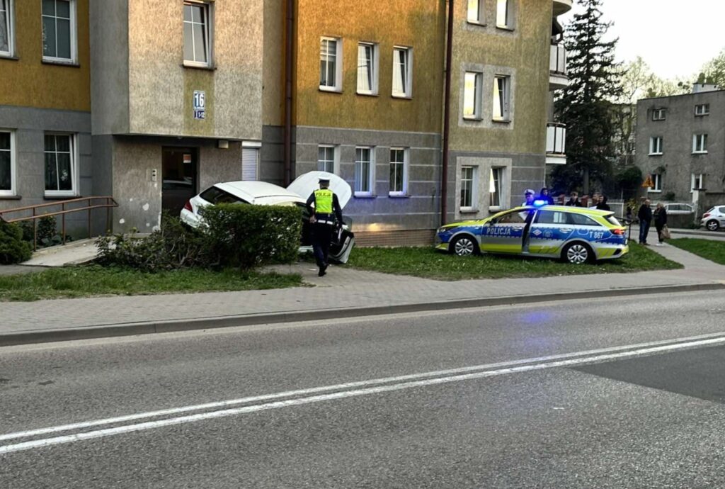 A Police Officer Walking On The Sidewalk Next To A Car That Crashed Into A Building Mercedes Wjechał Pod Klatkę Schodową
